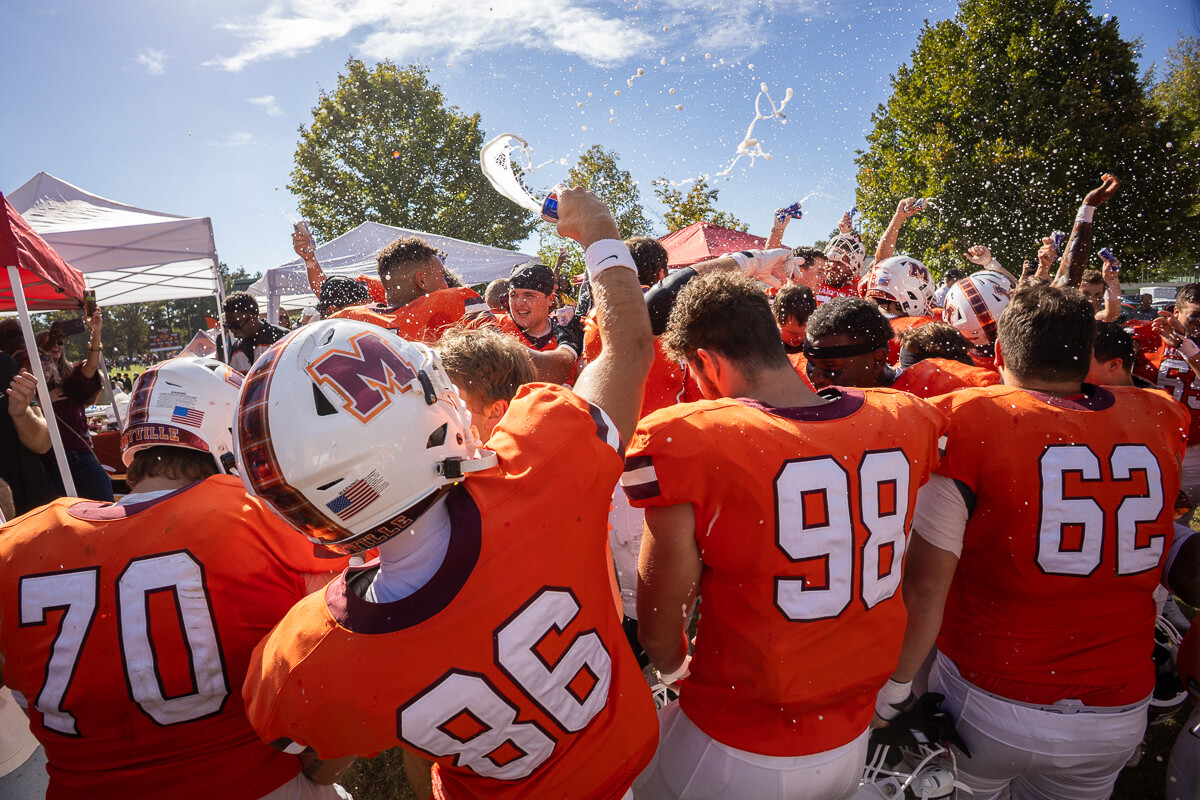 Photo of victorious Maryville College football players spraying themselves with beer on Victory Hill
