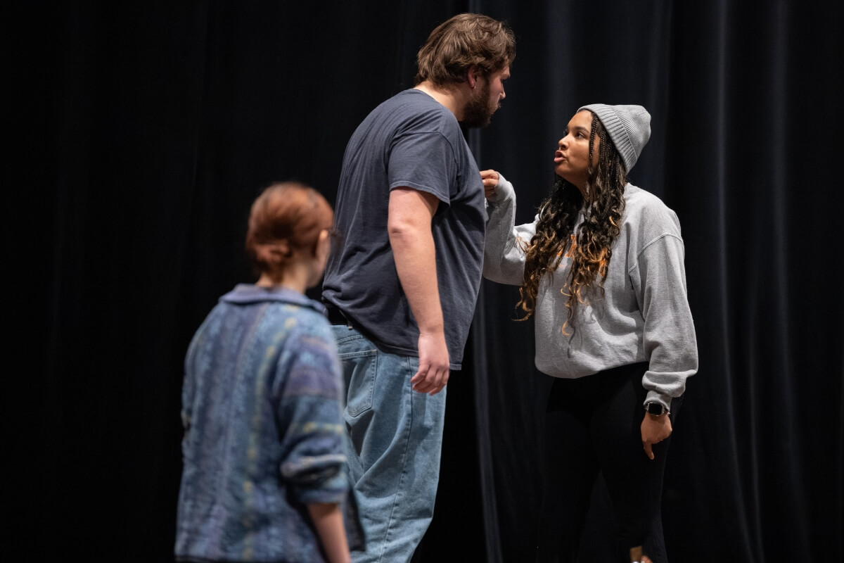 Photo of Trevor Morency '26 and two Maryville College actresses during a scene from "The Crucible."