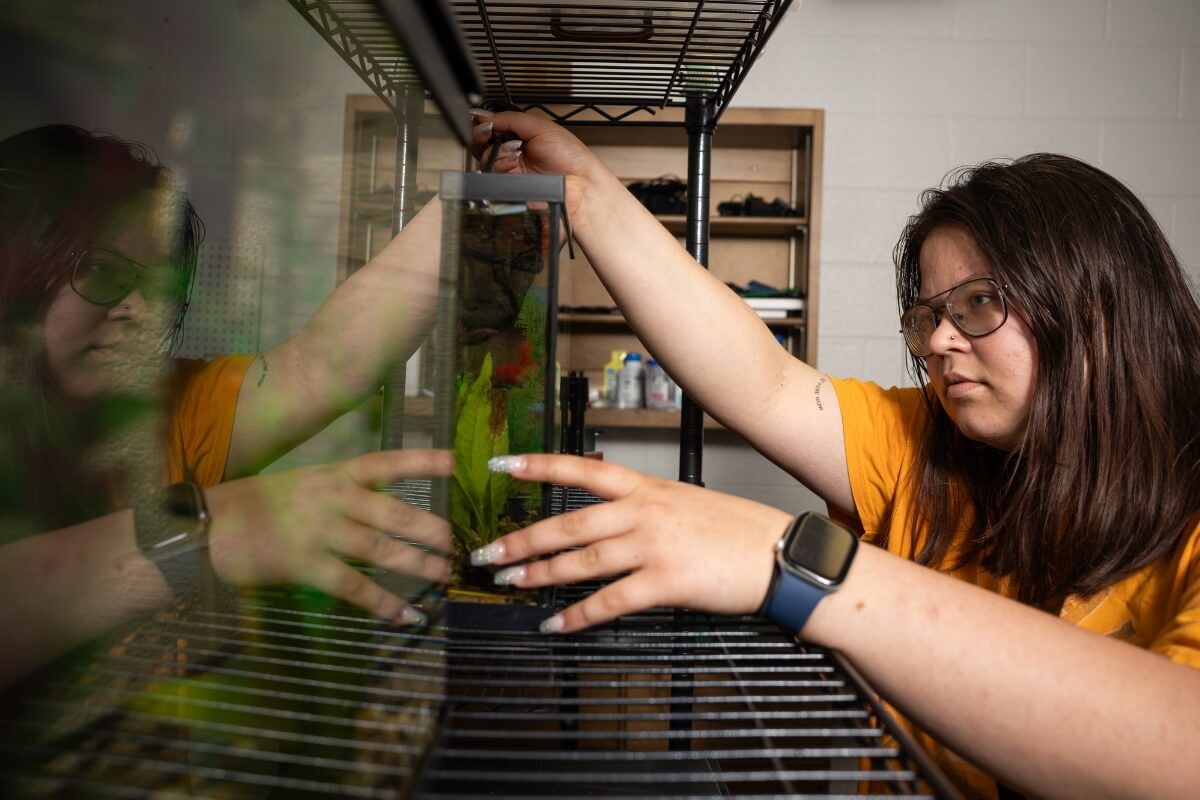 Photo of Sami Sasinouski feeding fish