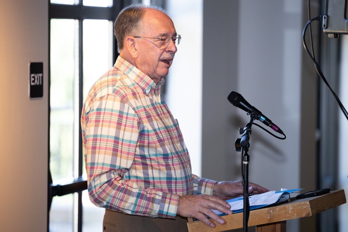 Photo of Tom Taylor '70 speaking to a crowd of people off camera