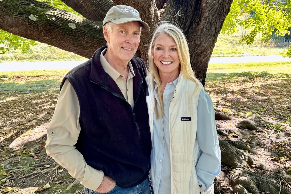Photo of a couple standing in front of a tree