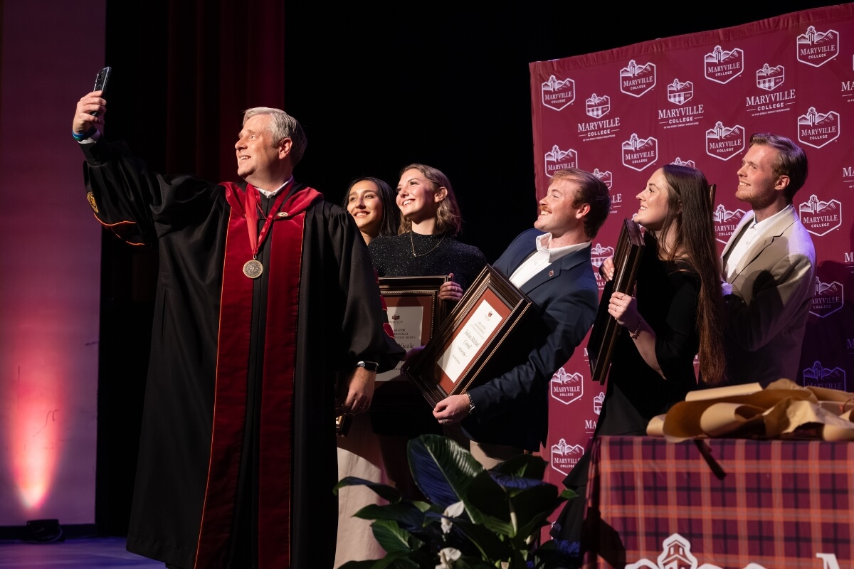 Photo of Dr. Bryan Coker taking a selfie with the Outstanding Senior Award finalists