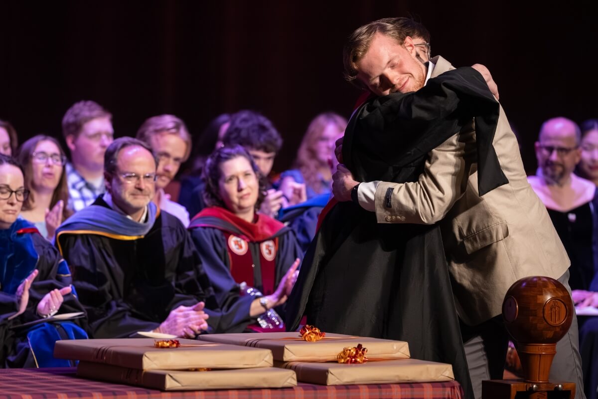 Photo of a student hugging a faculty member