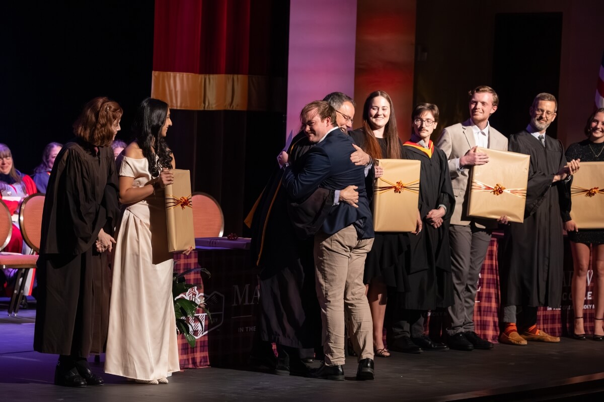 Photo of Josh Cornell hugging his faculty advisor