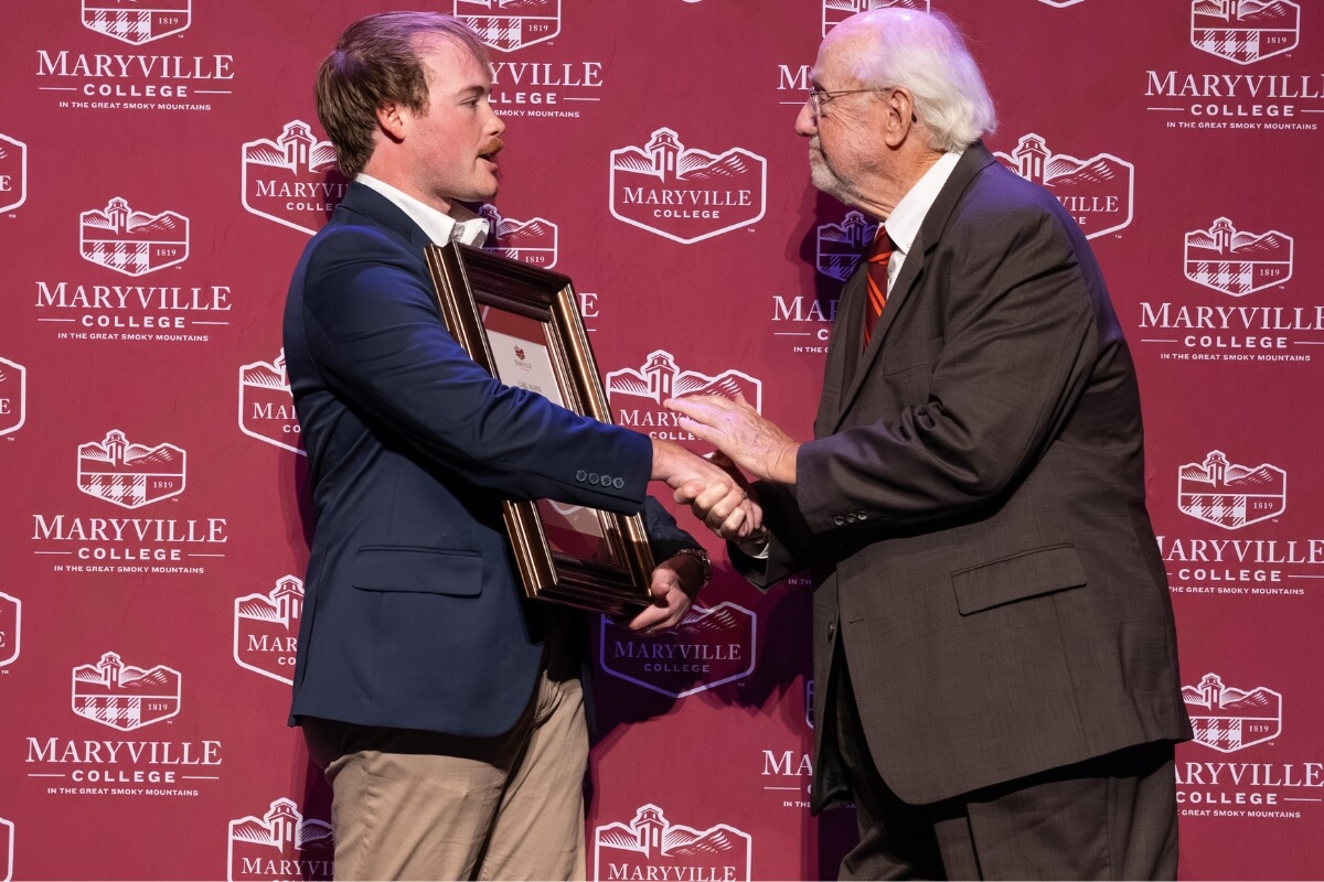 Photo of an old man shaking a young man's hand