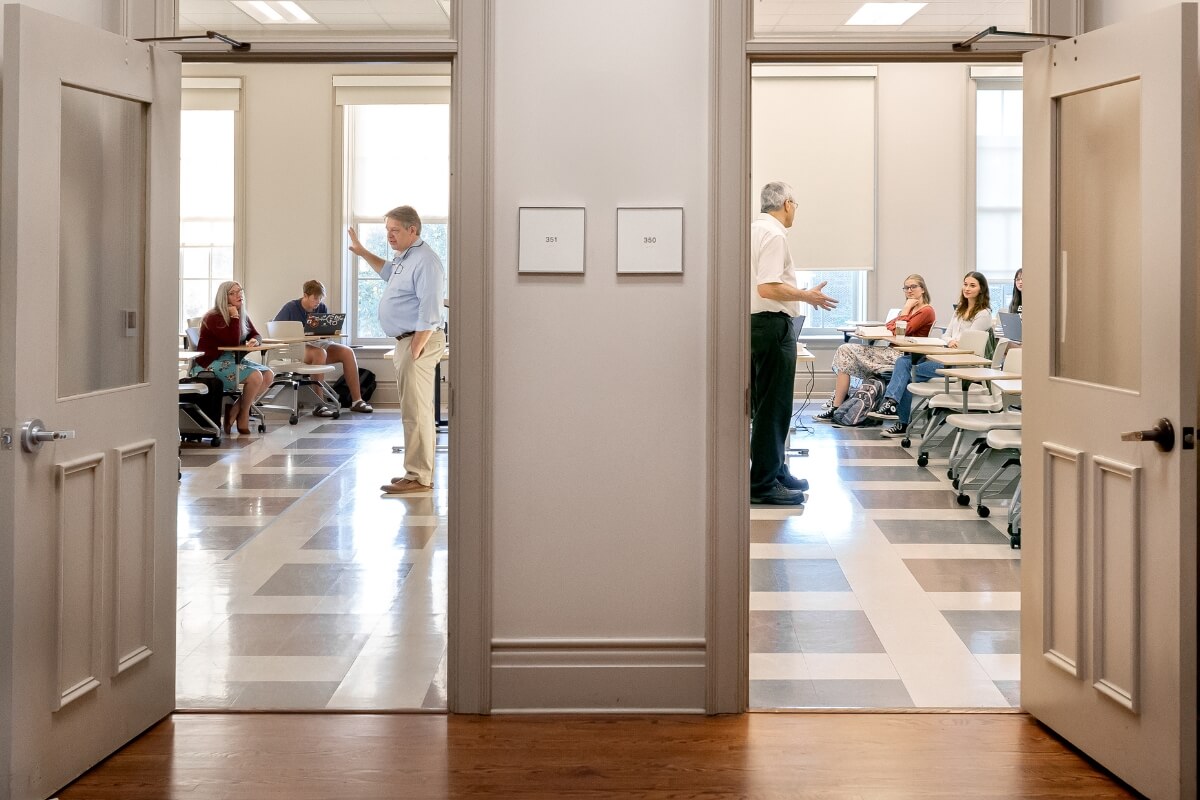 Photo of two open Anderson Hall classrooms with faculty members teaching assembled students