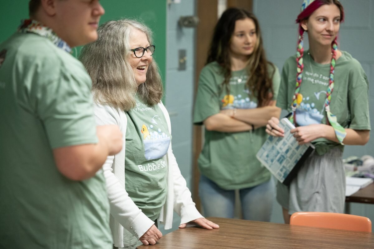 Photo of Barbara Johnson surrounded by students in a classroom