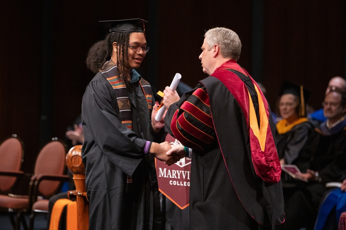 Photo of Lavarius Thenthirath, one of 37 Maryville College December graduates, receiving his diploma from Dr. Bryan Coker