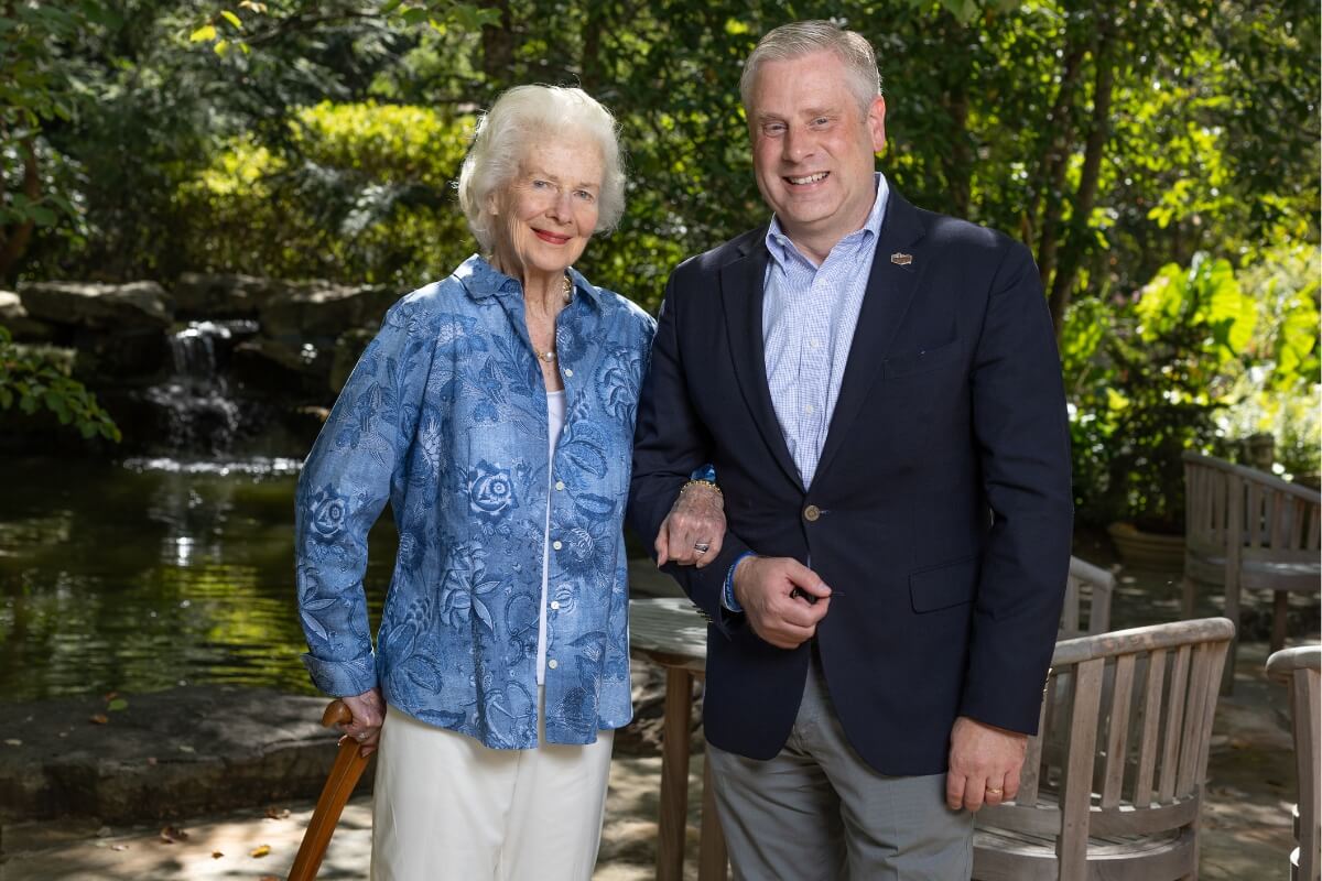 Photo of Natalie Haslam holding a smiling Dr. Bryan Coker's arm