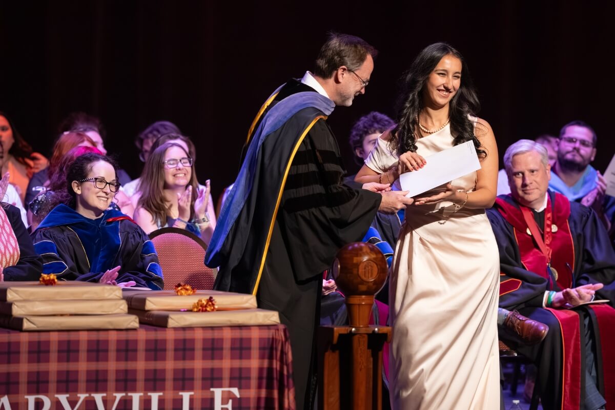 Photo of Dr. Scott Henson handing Rukshona Isomova an award
