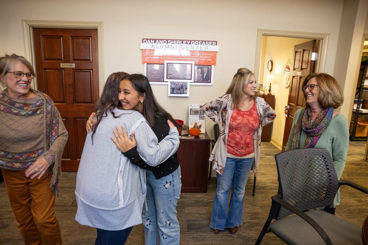 Photo of Rukhshona Isomova hugging another woman while other women look on and smile