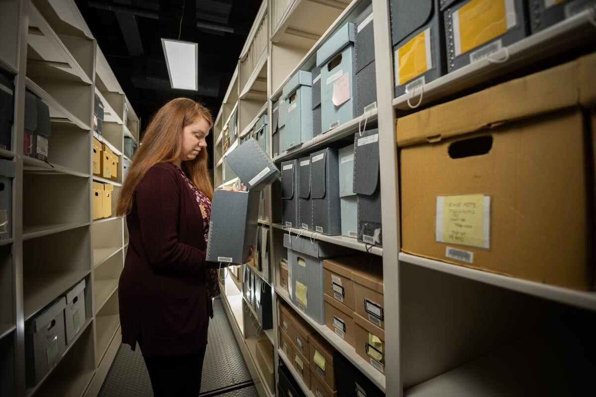 Photo of Amy Lundell '06 looking through the stacks in Maryville College's newly renovated Archives space.