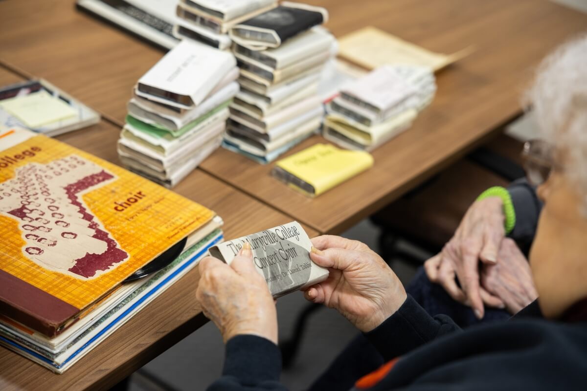 Photo of a woman looking at historical records of the Maryville College Concert Choir