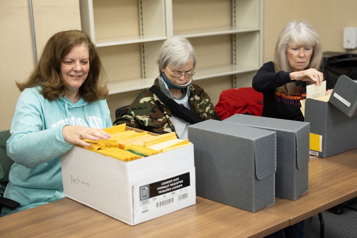 Photo of three women going through a box of file folders in the Maryville College Archives