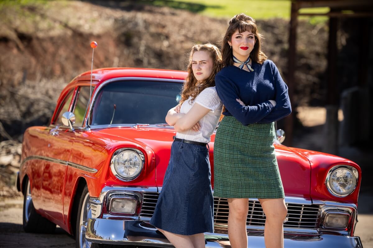 Photo of two Maryville College students standing in front of a classic car