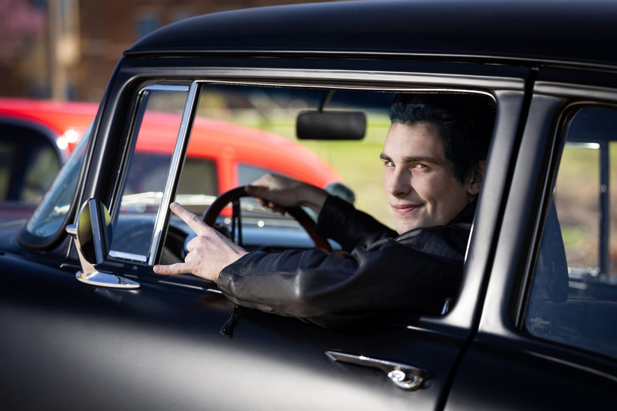 Photo of Maryville College student Ian Bailey leaning out the window of a car, smiling sardonically