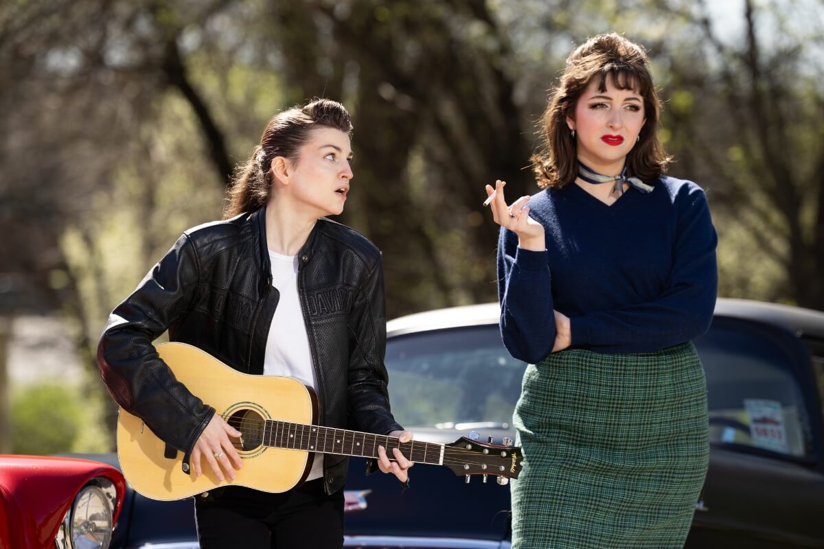 Photo of a student with a guitar attempting to impress another student