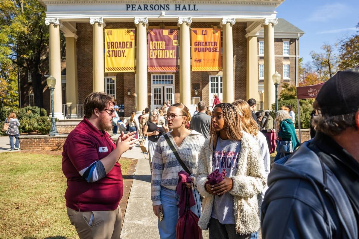 Photo of an Admissions ambassador speaking to students and parents at a November 2025 "Meet Maryville" event.