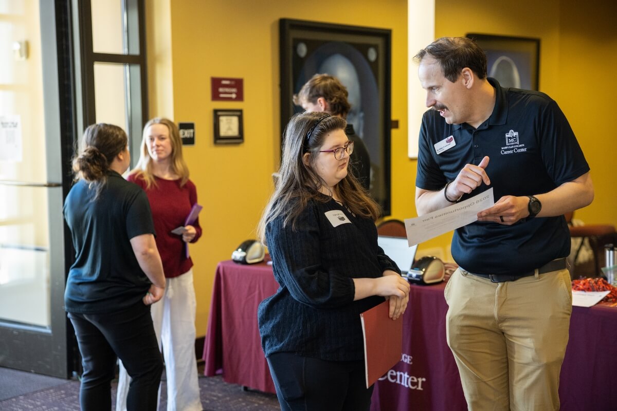Photo of a man giving information to an inquisitive young woman
