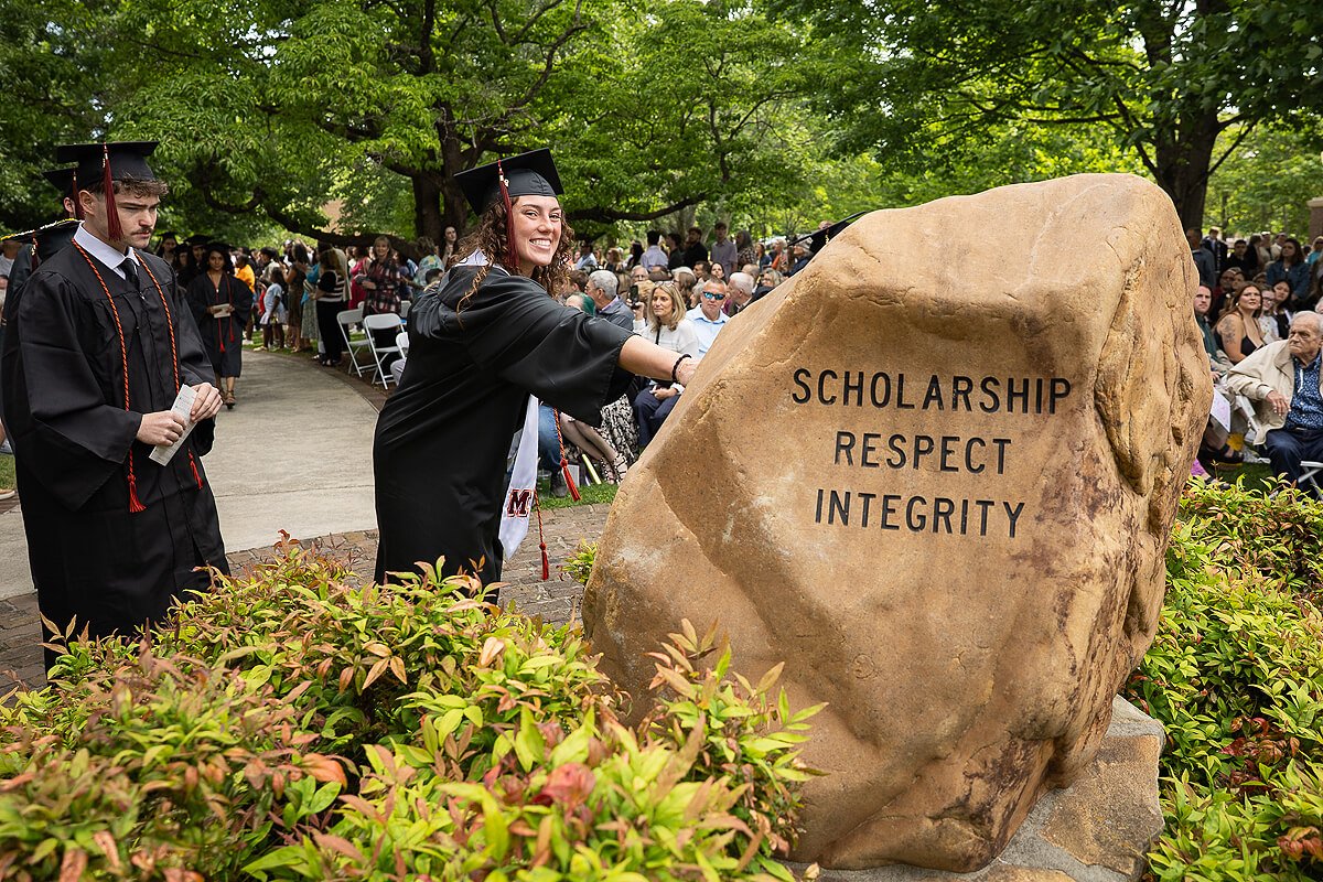Photo of a student touching a rock during Maryville College graduation 2026