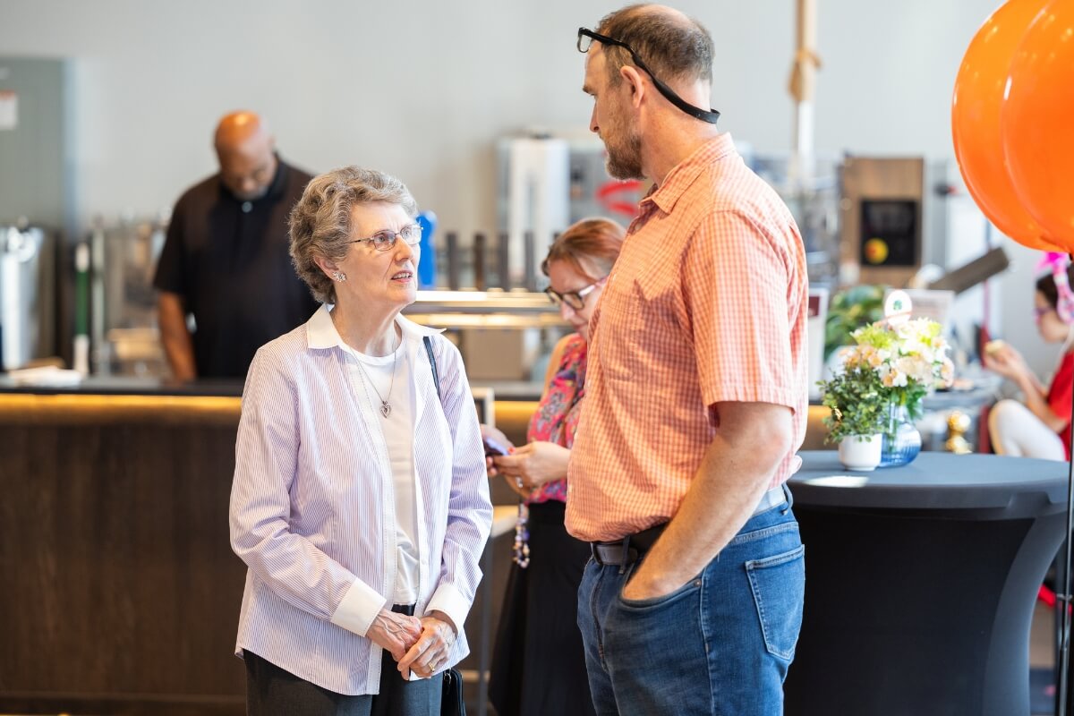 Photo of a short older woman talking to a taller man at the Maryville College Carnegie Classification celebration