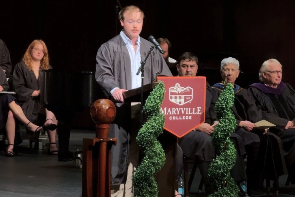 Photo of a college senior standing at a podium and giving an address