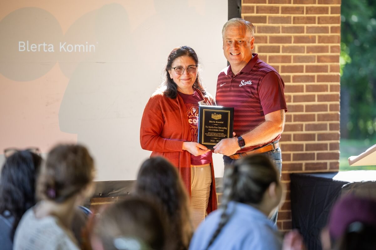 Photo of a man and a women holding a plaque and smiling