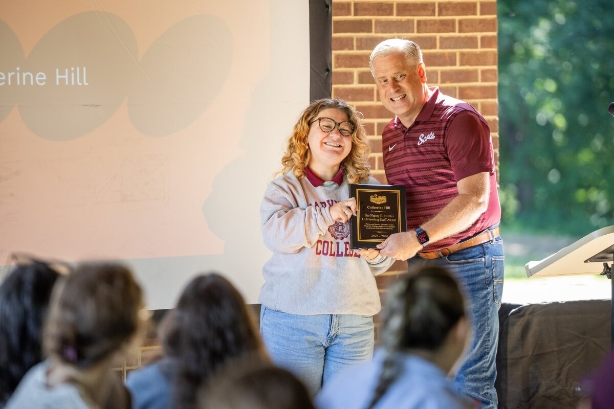 Photo of two people holding a plaque