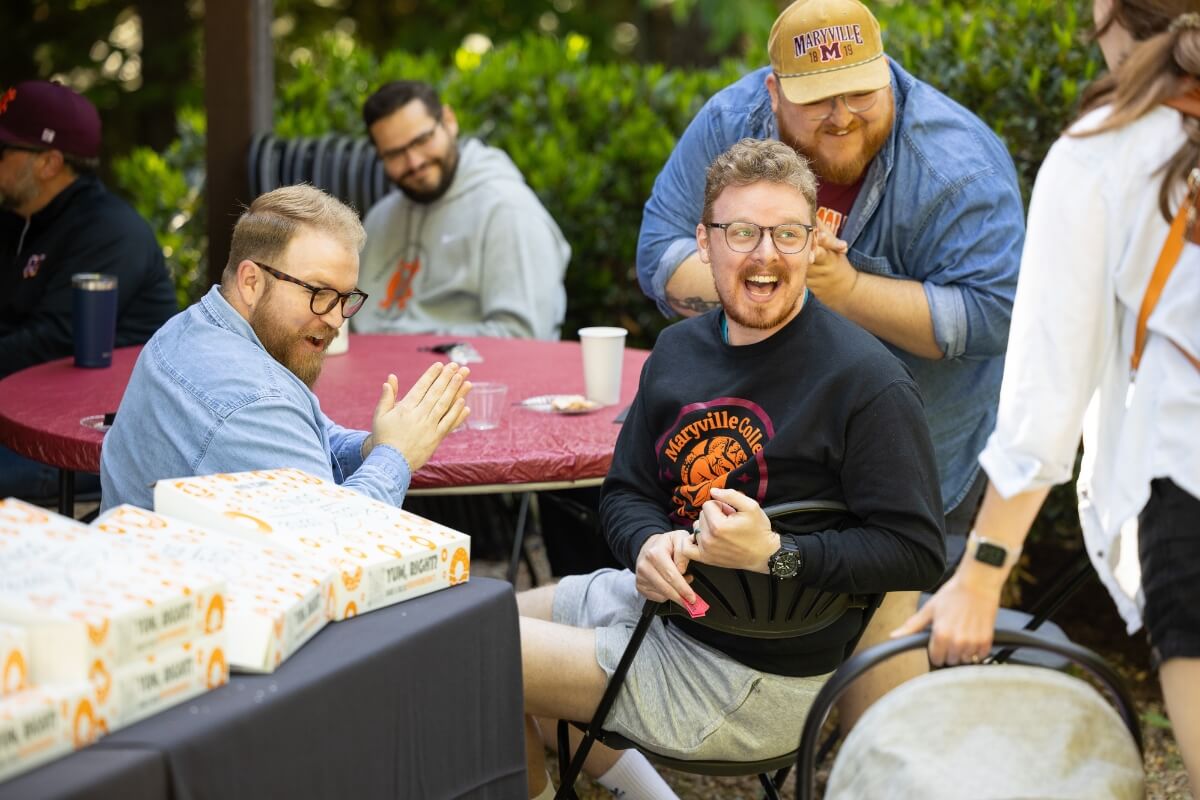 Photo of four men laughing