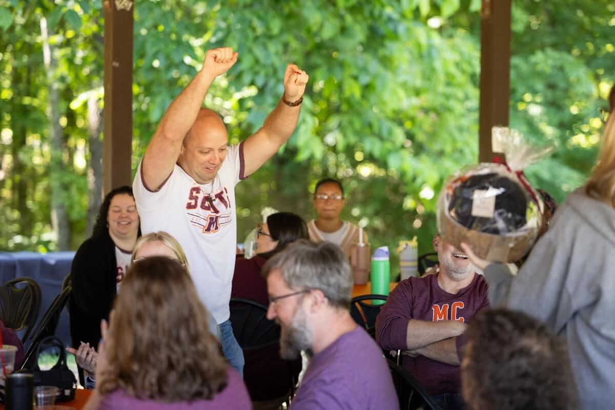 Photo of an excited man raising his arms
