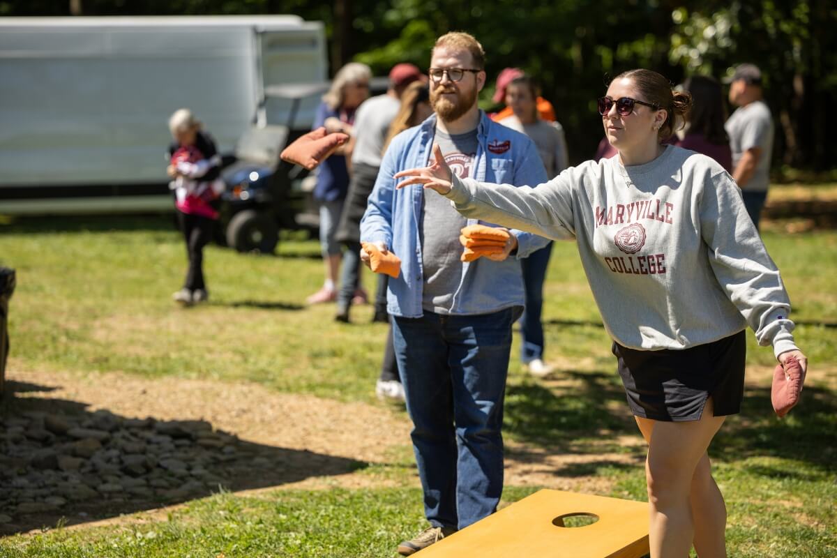 Photo of a man and a woman competing at cornhole