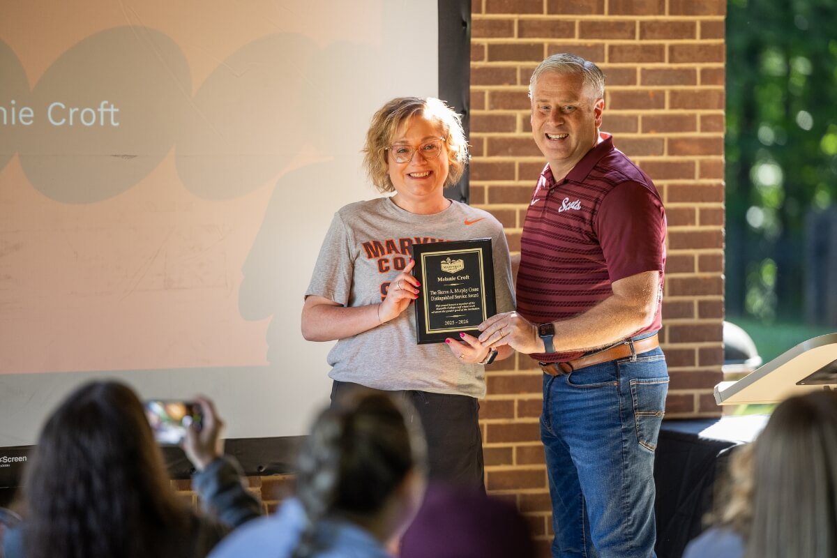 Photo of a woman holding a plaque with a man beside her